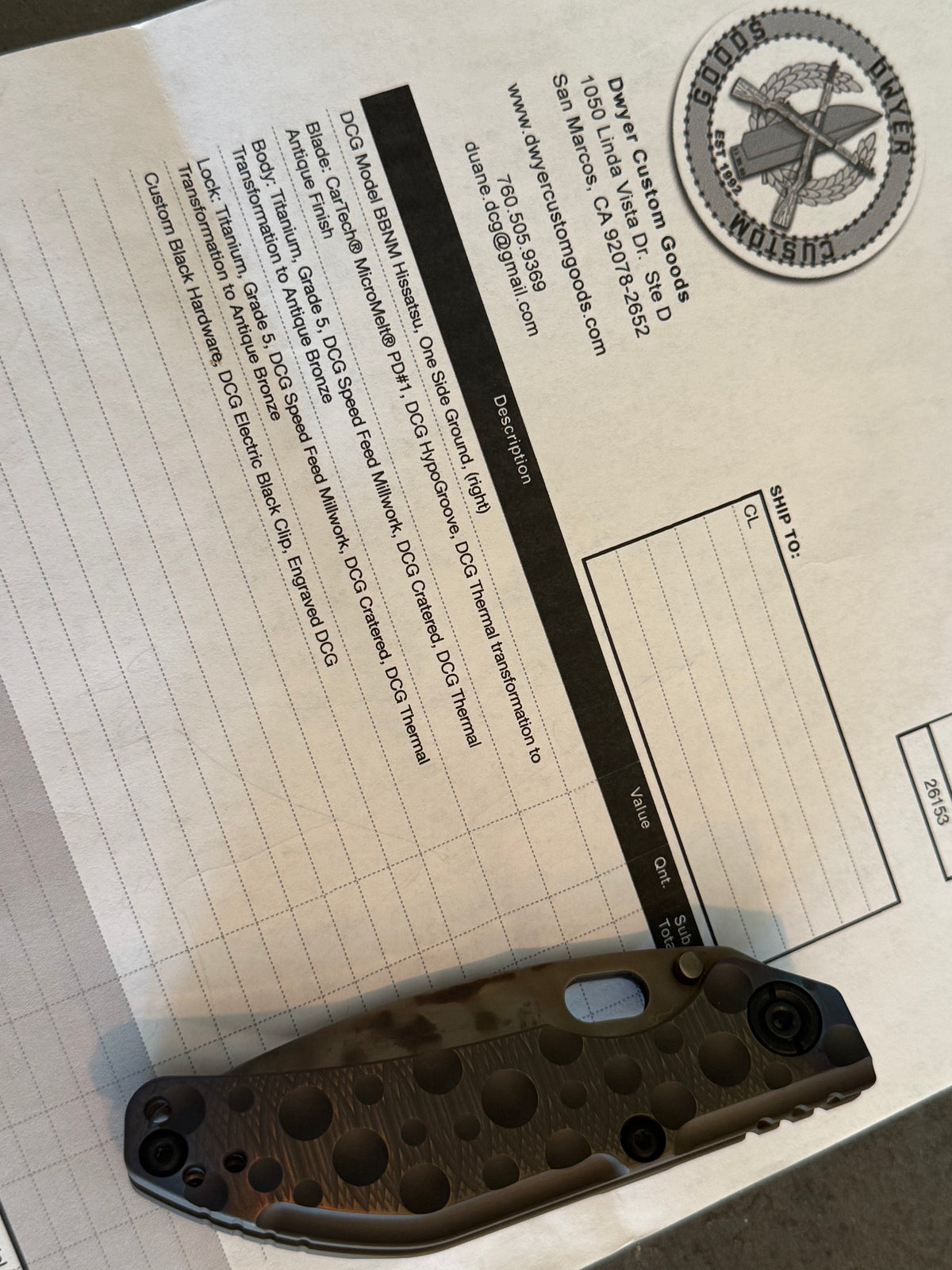 Closed Duane Dwyer BBN-M Hissatsu cratered Grade 5 titanium knife displayed with Dwyer Custom Goods specification paperwork.