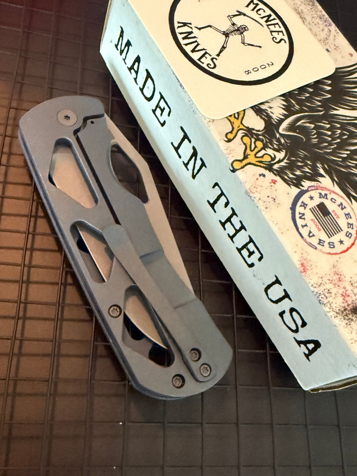 McNees Dixon 3.75 closed folding knife showing skeletonized blue titanium handle and matching pocket clip