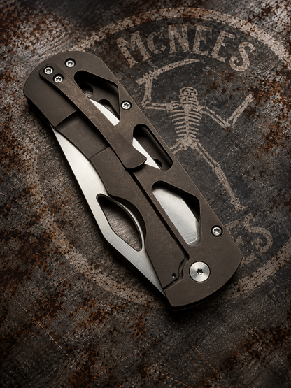 McNees Dixon 3.75 closed folding knife with bronze anodized skeletonized titanium handle and satin stonewashed hardware