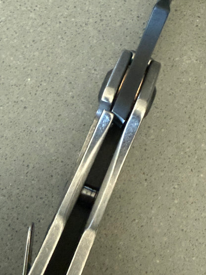 Mick Strider SnG Battleship MagnaCut knife showing titanium frame lock, matching camouflage pocket clip and blacked-out hardware
