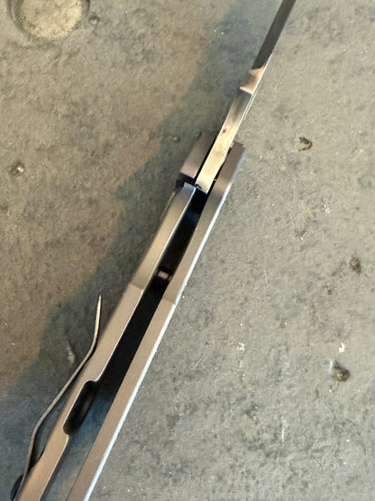 Spine detail of Duane Dwyer BBN-M Hissatsu folding knife showing titanium handle construction, blade alignment and frame lock.