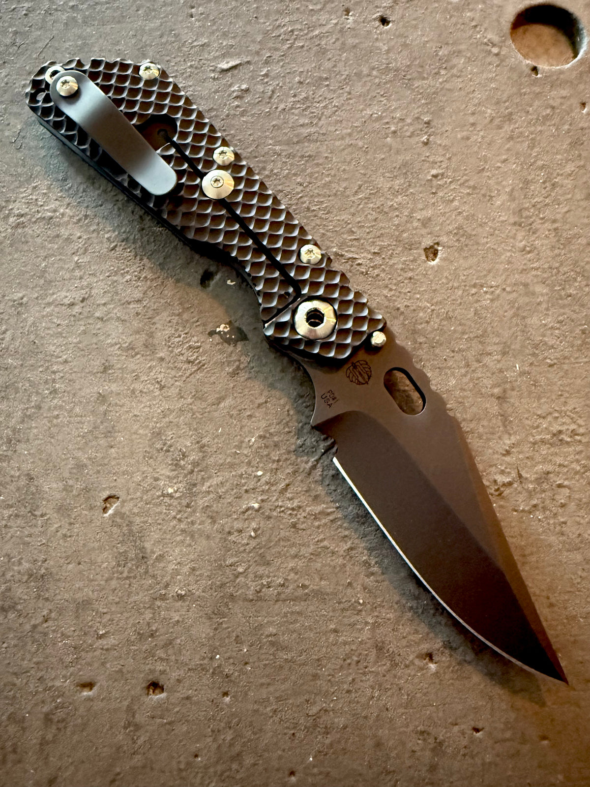 Strider SMF Double Gunner Grip titanium frame-lock side showing textured DGG milling, titanium pocket clip, upgraded hardware and black PD1 Bowie blade.