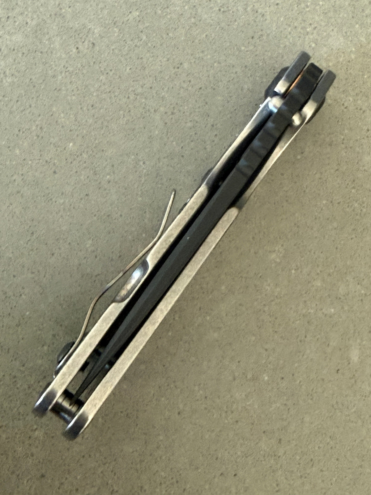 Strider SnG Battleship Blade Show West limited edition promotional image featuring black MagnaCut blade and laser camouflage titanium handle