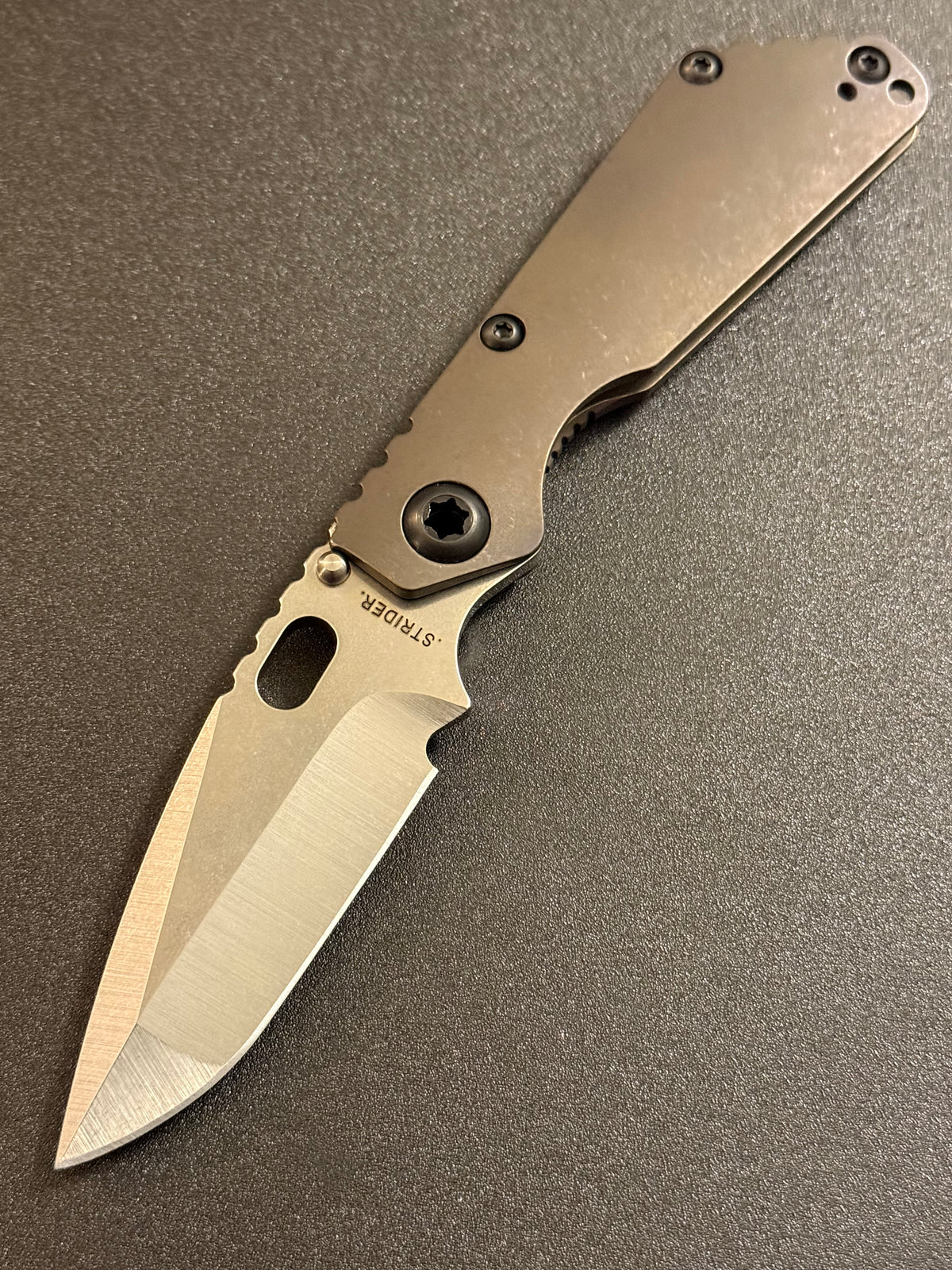 Strider SnG CC Compound Grind CPM MagnaCut folding knife with full Acid Bronze titanium handles, presentation side view.