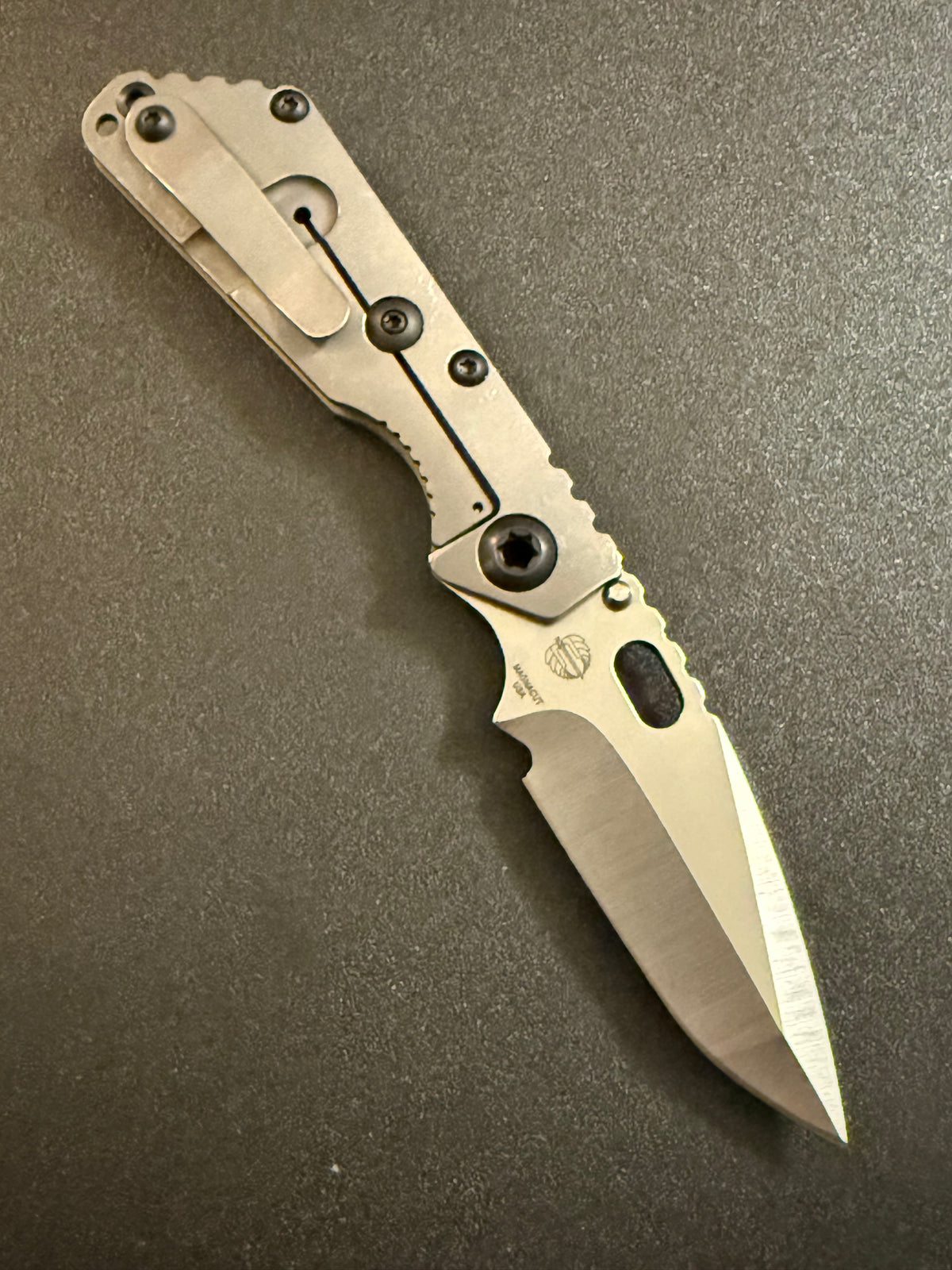Strider SnG CC MagnaCut compound grind knife showing acid-washed titanium frame lock, titanium pocket clip and precision-ground blade.