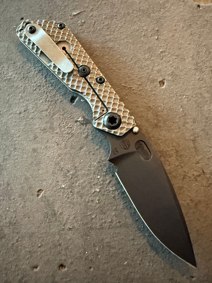 Strider SnG Double Gunner Grip titanium frame-lock side showing matching DGG milling, pocket clip, premium black hardware and PD1 black blade.