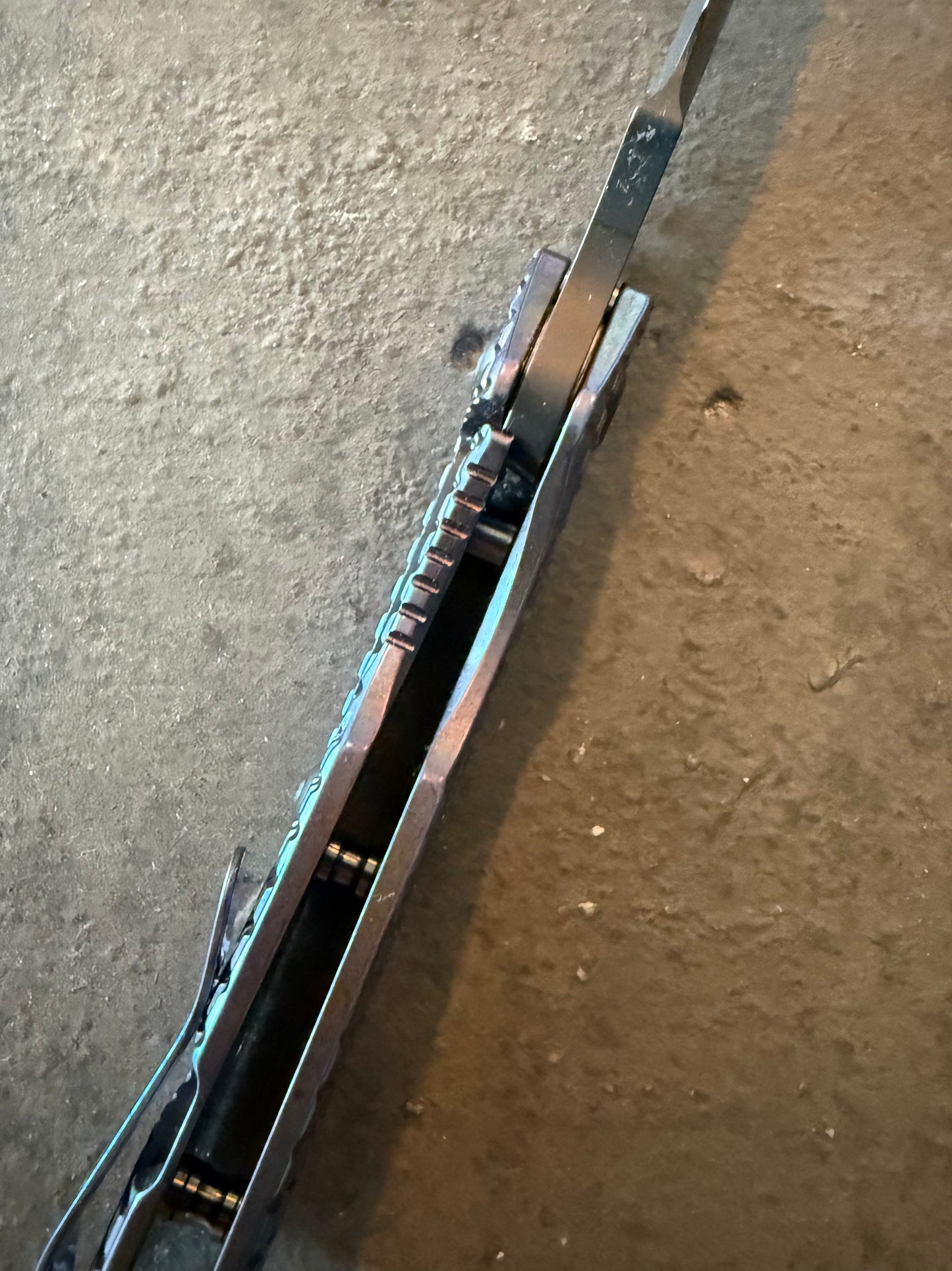 Top spine view of Strider SMF Monkey Edge FRAG showing titanium handle construction, blade spine, jimping and open-back design.