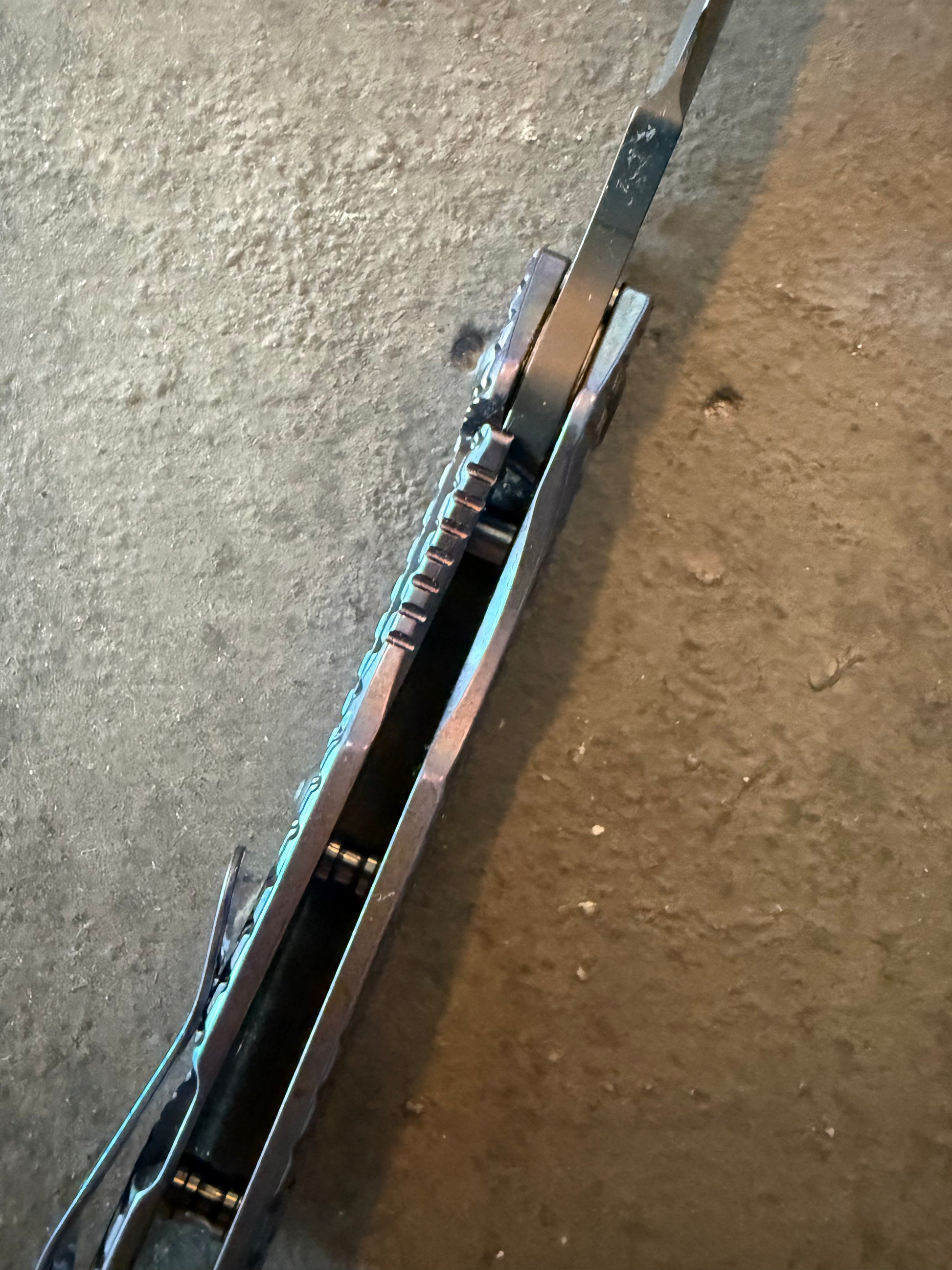 Top spine view of Strider SMF Monkey Edge FRAG showing titanium handle construction, blade spine, jimping and open-back design.