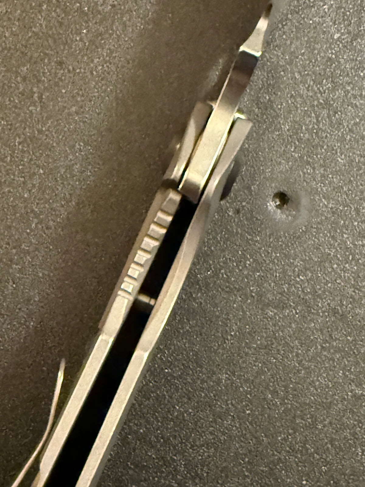 Top view of Strider SnG CC full titanium folding knife displaying blade spine, titanium handle construction and open-back standoffs.